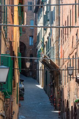 Siena, İtalya 'da eski binalar ve kemerli sokak manzarası