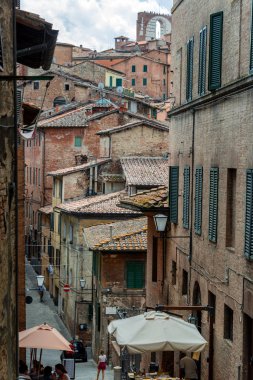 Siena, İtalya 'da eski binalar ve kemerli sokak manzarası