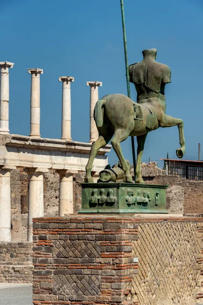 Statue of a Centaur, a mythical creature, half horse and half man, displayed in the ruined city of Pompeii with Mount Vesuvius in the background