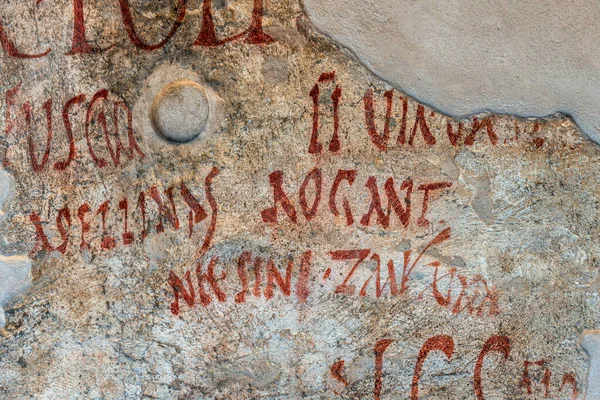 Pompeii 'deki harabelerden birinin duvarına antik Latince graffiti yapılmış. Pompeii kazılarında 11.000 'den fazla grafiti örneği ortaya çıkarıldı. Yazı