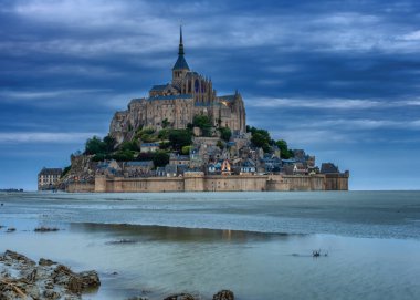 Mont saint michel aydınlanmış mimari panoramik güzel kartpostal görüntüsü Dusk, Summer Low Tide 'da köprüden yansıyan yansımayla, Fransa