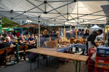 İnsanlar Viyana, Avusturya 'daki Naschmarkt pazarının ünlü bölgesinde öğle yemeği yiyorlar. Naschmarkt, 16. yüzyıldan beri popüler.