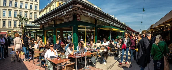 İnsanlar Viyana, Avusturya 'daki Naschmarkt pazarının ünlü bölgesinde öğle yemeği yiyorlar. Naschmarkt, 16. yüzyıldan beri popüler.
