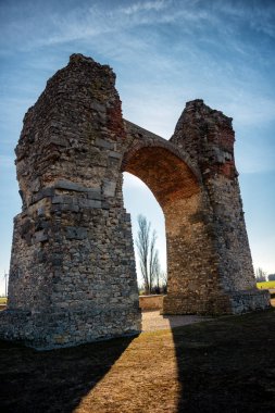 Avusturya, Carnuntum 'da Heidentor. Arka planda rüzgâr çiftliği olan tarihi Romalıların yerleşim yeri.