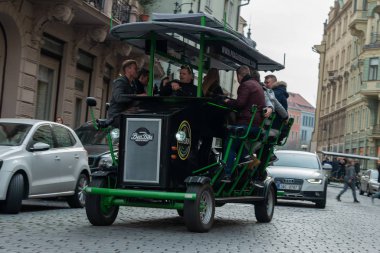 People riding the pedaling bar, Party bike or Beer Bike through the old town of Prague