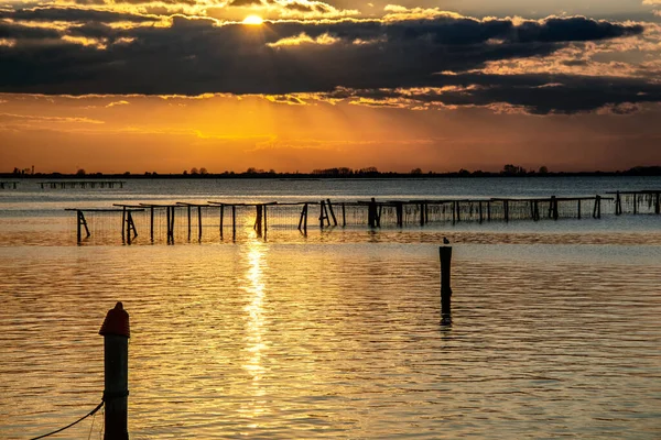 Stilt evinin üzerinde nefes kesici Sunset ve Po Delta boyunca balık ağları. İtalya