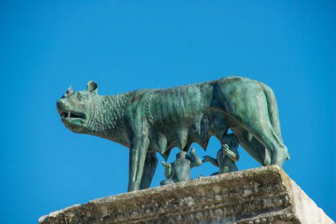 Bir dişi kurt tarafından emzirilen Romulus ve Remus heykeli. Kuzey İtalya 'da antik bir Roma şehri olan Aquileia Ataerkil Bazilikası' nın çan kulesinin önünde yer almaktadır.. 