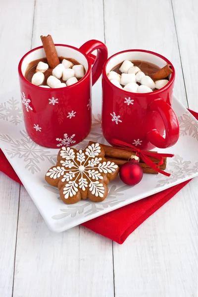 Canecas vermelhas com chocolate quente e marshmallows e biscoitos de gengibre — Fotografia de Stock