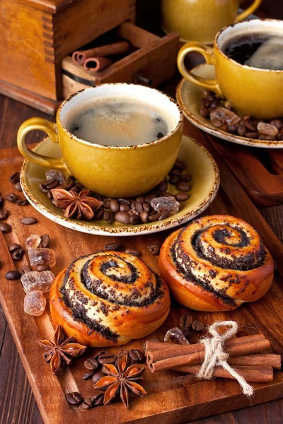 Bakad söta bullar med vallmo och kaffe på trä bord — Stockfoto