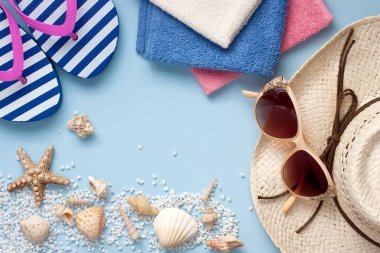 Plaj havlusu, güneş gözlüğü ve şapka ahşap arka plan üzerinde