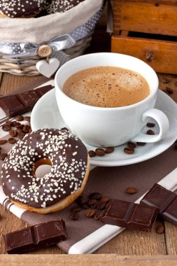 Kahve ile ahşap bir masa üzerinde süt ve çikolata çörek