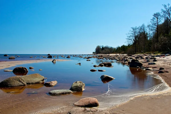 Solljus dag på havet med stora stenar på kusten — Stockfoto