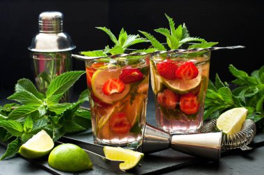 Çilekli mojito kokteyli karanlık masada gözlüklü.