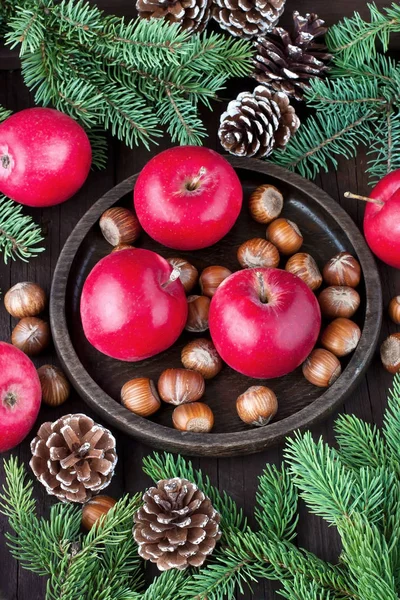 Red winter apples with nuts and fir-tree branches — Stock Photo, Image
