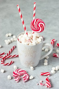 Noel bardağında beyaz ve kırmızı nane şekeri çubukları ve lokum.