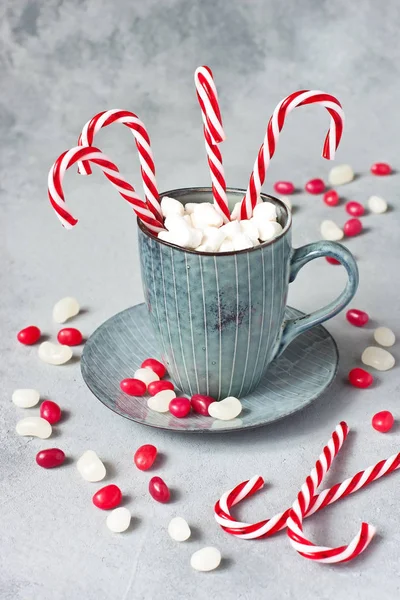 Bastones de caramelo con rayas rojas y blancas en taza de cerámica — Foto de Stock