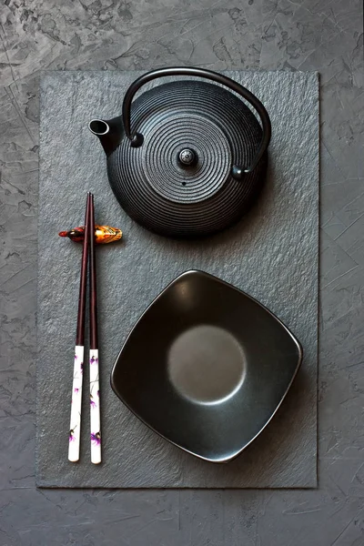 Вид сверху на палочки и посуду на темном фоне — стоковое фото