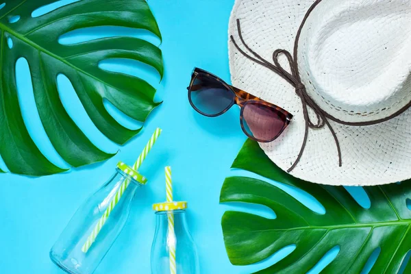Tillbehör i tropisk stil - hatt, solglasögon, monstera blad — Stockfoto