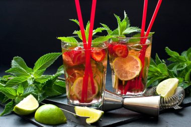 Çilekli mojito kokteyli karanlık masada gözlüklü.