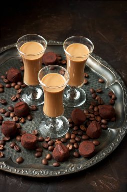 Koyu arka planda shot bardaklarında kremalı likör, seçici odaklanma