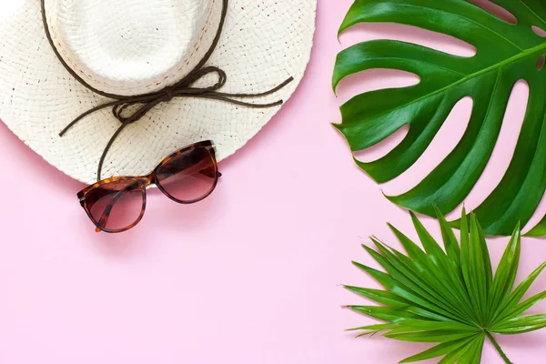 Gafas de sol y sombrero de mimbre sobre fondo de color — Foto de Stock