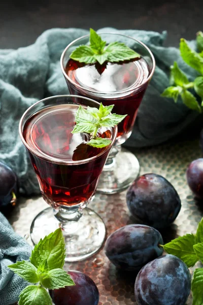 Plum wine or liquor on dark  background and ripe juicy plums — Stock Photo, Image