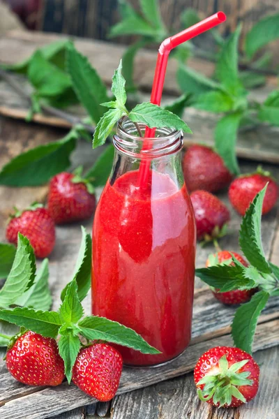 Bardakta çilekli smoothie kokteyl pipetli, seçici odaklı.