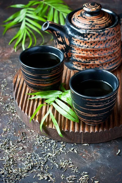 Asiático estilo tigelas de cerâmica e bule de chá no fundo escuro — Fotografia de Stock