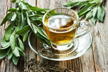 Cam bardakta adaçayı ve ahşap masada adaçayı.