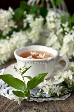 Yasemin çiçekleri ve rustik arka plan üzerinde çay