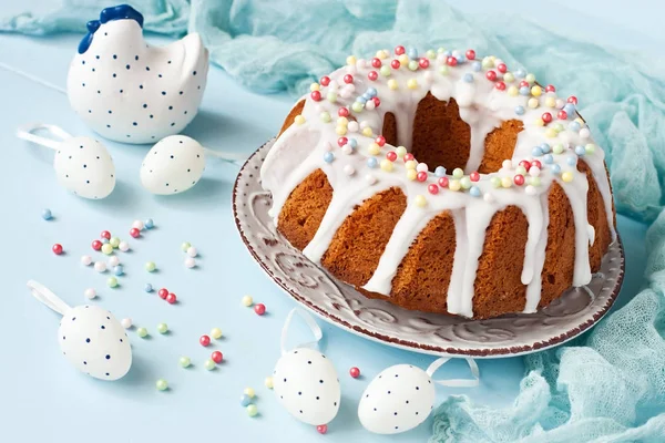 Tasty easter cake with ceramic chicken and decorative eggs  on wooden table