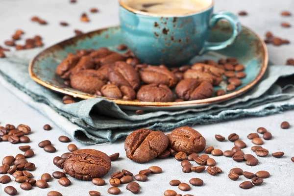 グレーの背景にコーヒーカップとブループレート上のコーヒーの形のクッキー 選択的焦点 — ストック写真