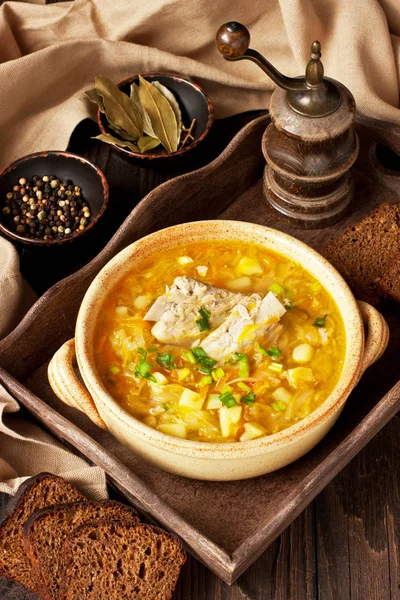 Cabbage soup -  traditional dish of Russian national cuisine. Soup in  ceramic   bowl and  rye bread  on wooden table