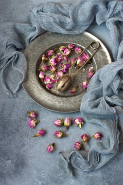 Tepside kurutulmuş gül tomurcukları çay ve vintage elek ile Kompozisyon 