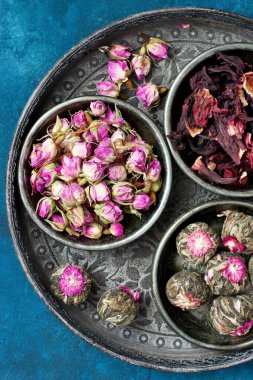 Çay yaprakları, gül tomurcukları, tepside yasemin çiçekli toplar. Üst manzara, düz uzanma