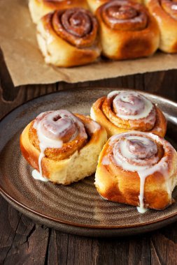 Şekerleme fırını. Dekoratif tabakta tarçınlı taze rulo çörekler