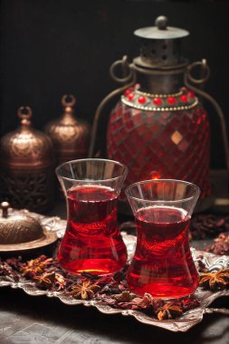 Taze demlenmiş kırmızı karkade çayı, doğu çay seremonisi, koyu beton arka planda.