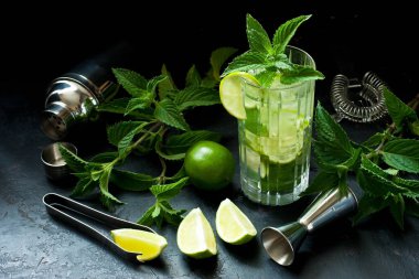 Naneli limon ferahlatıcı kokteyl mojito rom ve buzlu siyah arka planda cam.