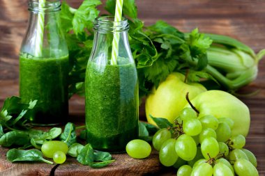  Yeşil ıspanak, salatalık, ahşap üzerine yeşil elma suyu doldurulmuş mason kavanozu.  