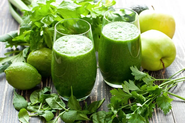 Sağlıklı yeşil smoothie ile salatalık, ıspanak, avokado ve kırsal arka planda yeşil camlar