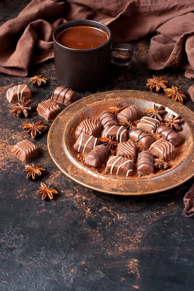 深色桌子上的巧克力糖和可可豆杯配料 — 图库照片