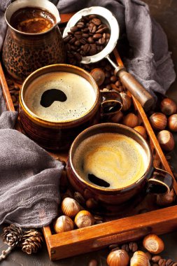 Kahveli seramik kupalar, tahta tepside eski kahve demliği.