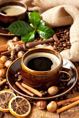 Kahve çekirdekli kahve fincanı, çuval içinde ahşap masa, seçici odak, sığ alan derinliği