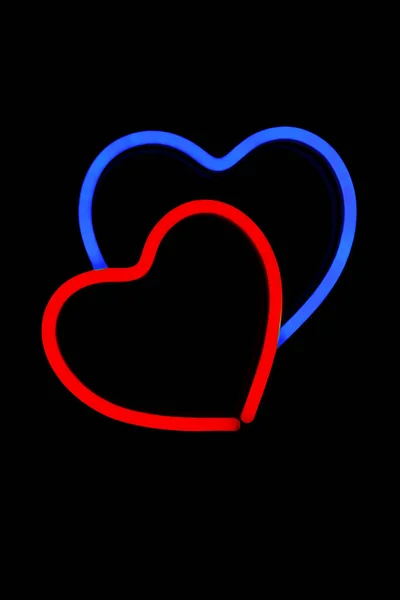 Coração vermelho e azul em um sinal de néon no fundo preto isolado . — Fotografia de Stock