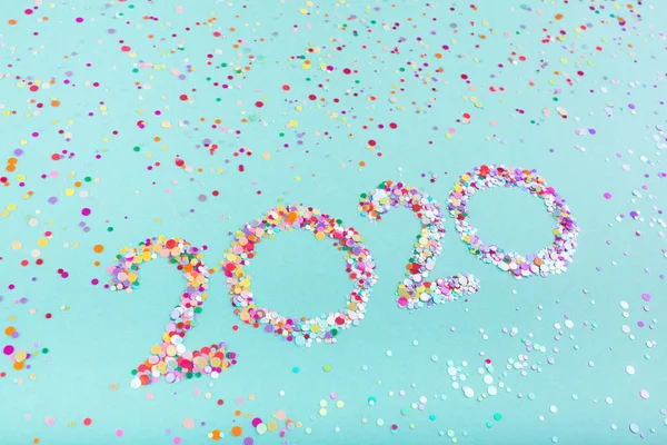 Número creativo 2020 escrito en brillo multicolor sobre un fondo de color menta . — Foto de Stock