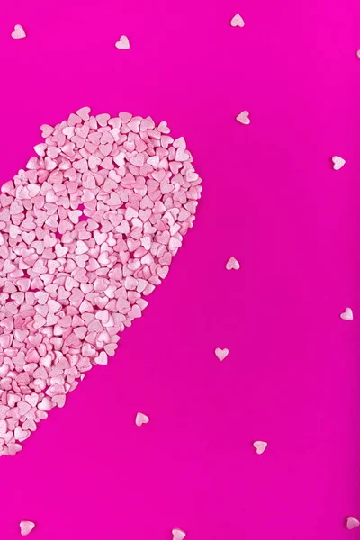 Bright pink background. Pink half a heart on a pink background. Hearts sprinkles. Valentine day. — Stock Photo, Image