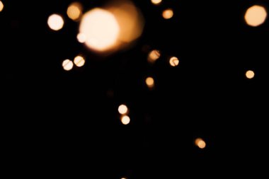 Siyah izole arka plan üzerinde Altın soyut bokeh ışıltı. Tatil konsepti.