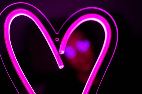 San Valentino. Hipster bell'uomo con segni al neon. Segno al neon cuore rosa . — Foto Stock