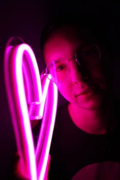 Valentine day. Hipster handsome man with neon signs. Neon sign pink heart. — Stock Photo, Image