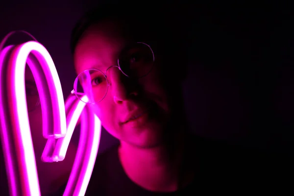 San Valentín. Hombre guapo Hipster con signos de neón. Signo de neón corazón rosa . — Foto de Stock